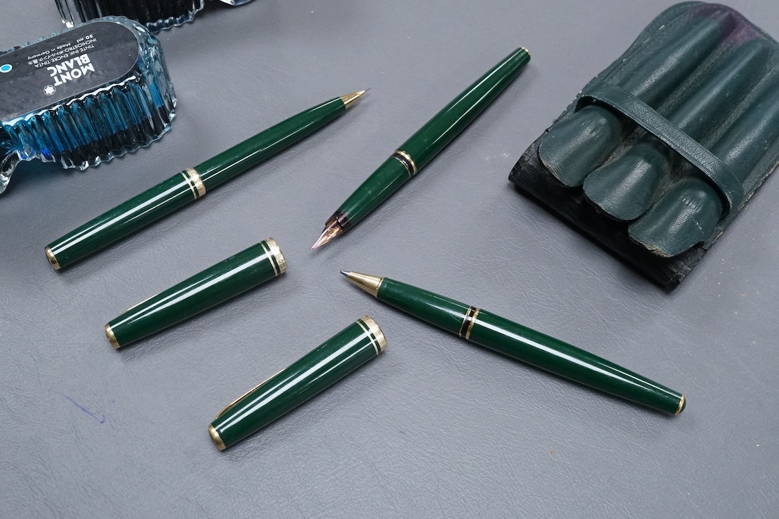 Three Mont Blanc pens in a green leather Mount Blanc case and two inkwells.